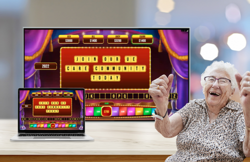 Excited older adult woman celebrates in front of a smart tv and tablet displaying the Spintopia game by Utopia Experiences