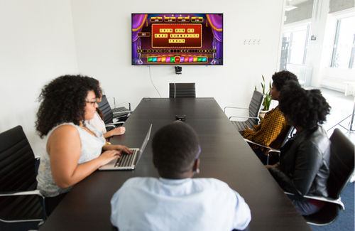 Community staff view the Spintopia game on a conference room TV monitor